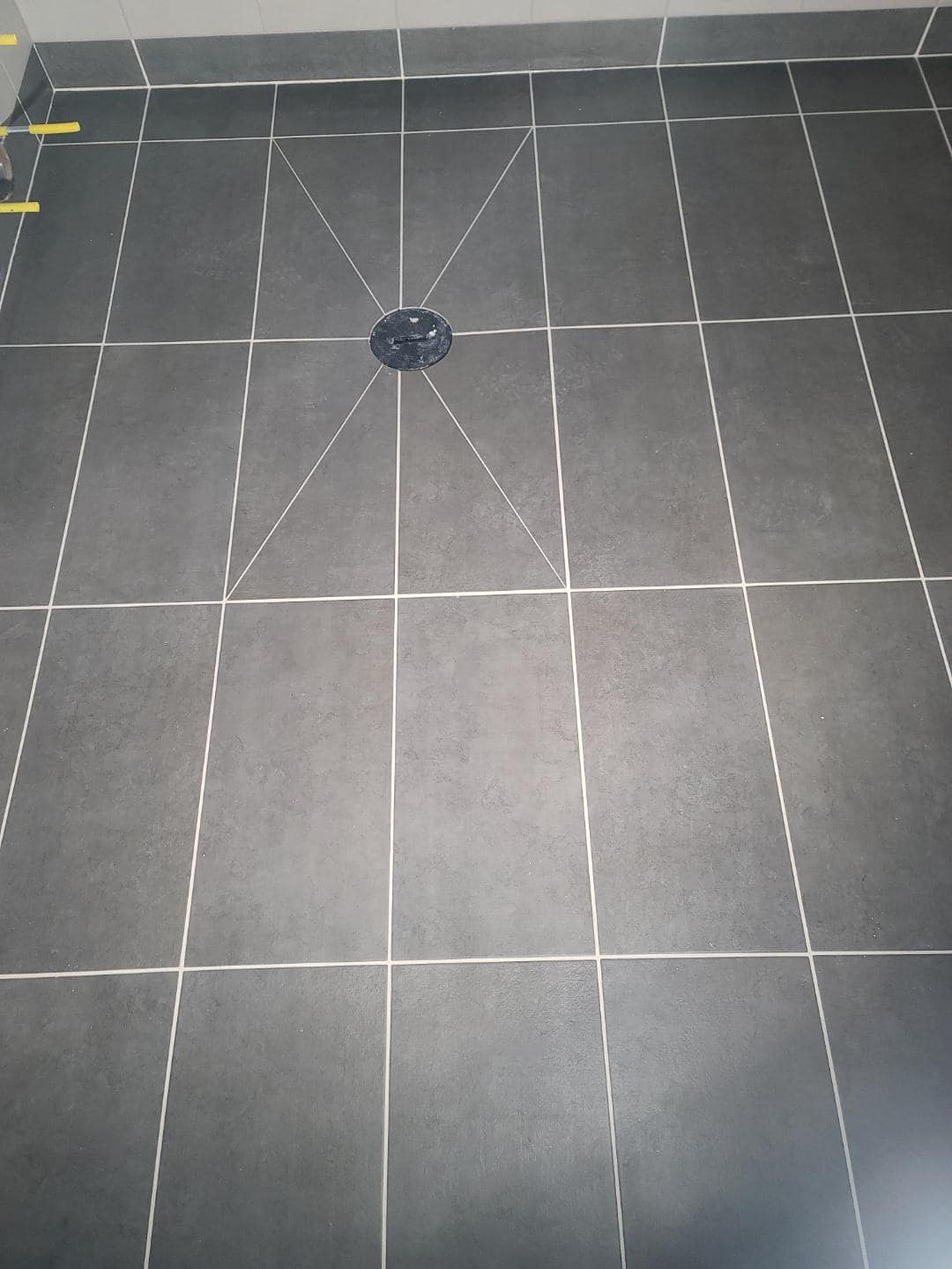 Precise installation of drain, with detail cuts of tiles in the floor by Cardinal Flooring and Supply of Klamath Falls and Medford. Southern Oregon.
